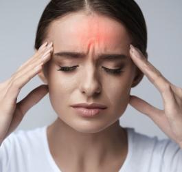 Kobieta zmaga się z silnym bólem głowy.